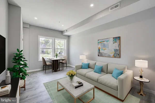 a living room with furniture a window and a potted plant