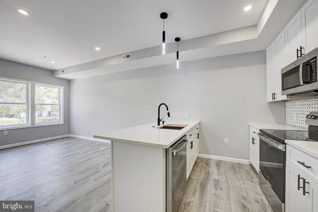 a kitchen with a sink stainless steel appliances and cabinets