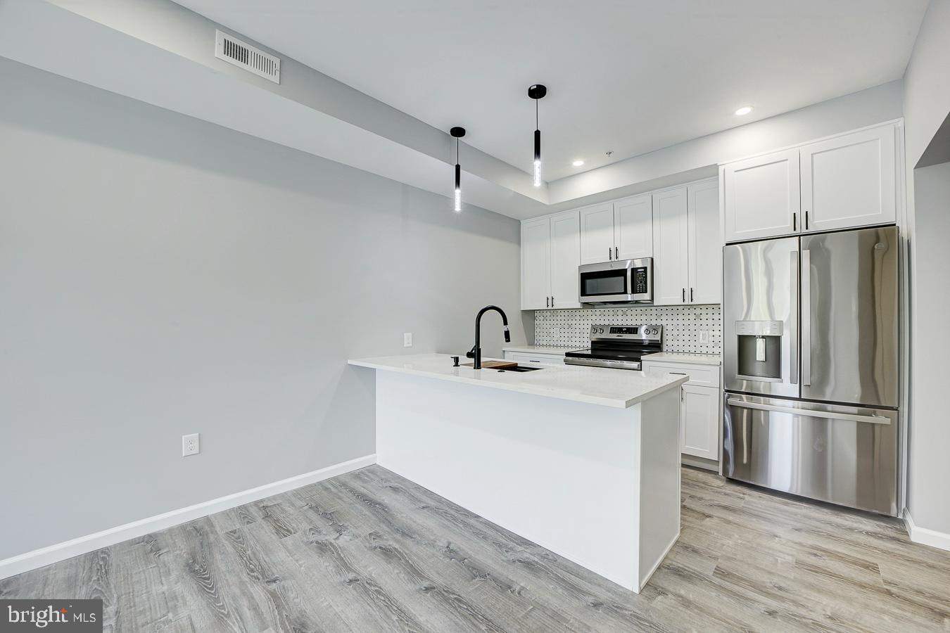 832 19th Street Northeast, Unit B Washington, DC 20002 - Photo 5 of 21 a kitchen with stainless steel appliances a refrigerator stove a sink and white cabinets
