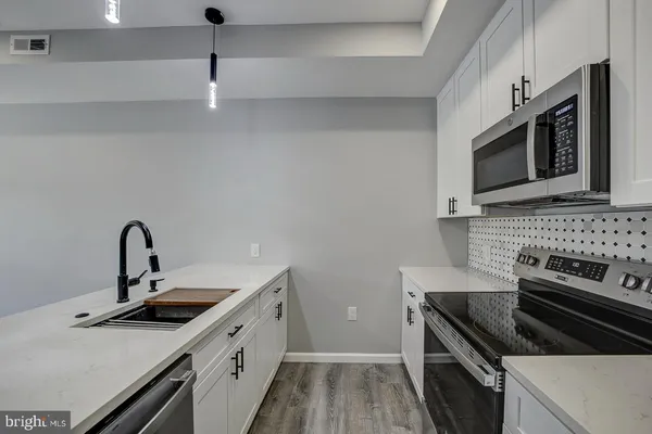 a kitchen with stainless steel appliances a sink stove and microwave