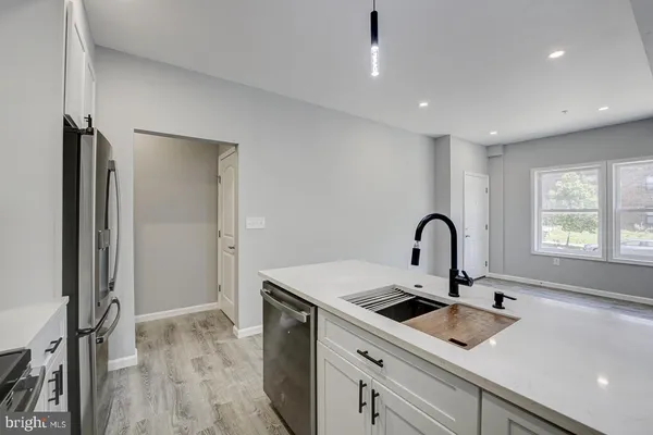 a kitchen with a sink a counter top space and stainless steel appliances