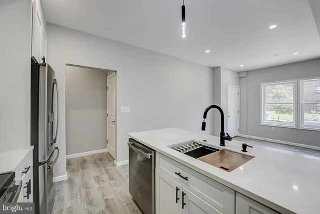 a kitchen with a sink a counter top space and stainless steel appliances
