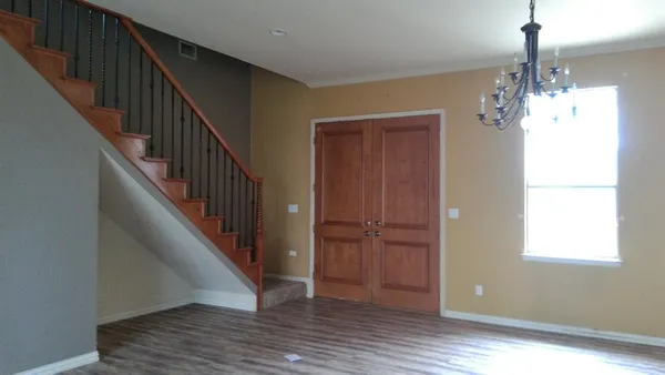 a view of a hallway with wooden floor and staircase