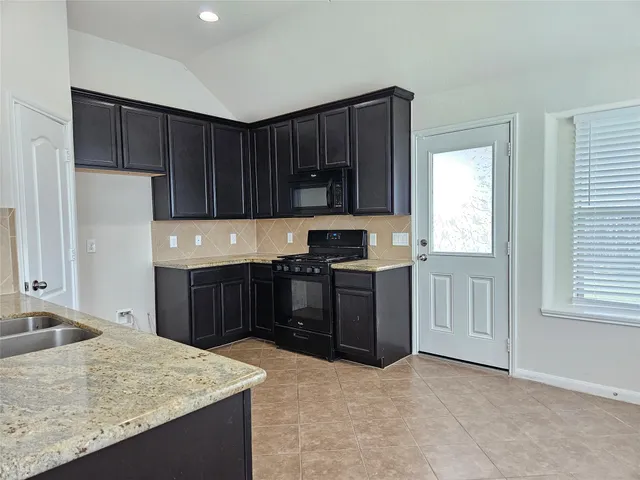 a kitchen with a refrigerator stove top oven a sink and dishwasher