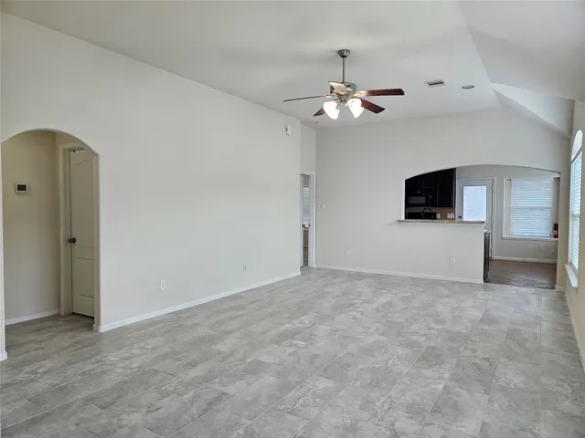 an empty room with windows and fireplace