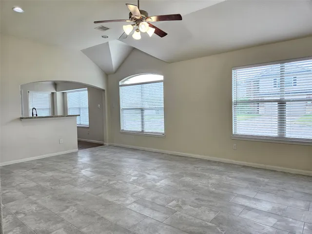 an empty room with windows and fan