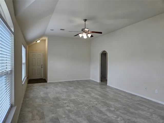 a view of an empty room with a chandelier fan