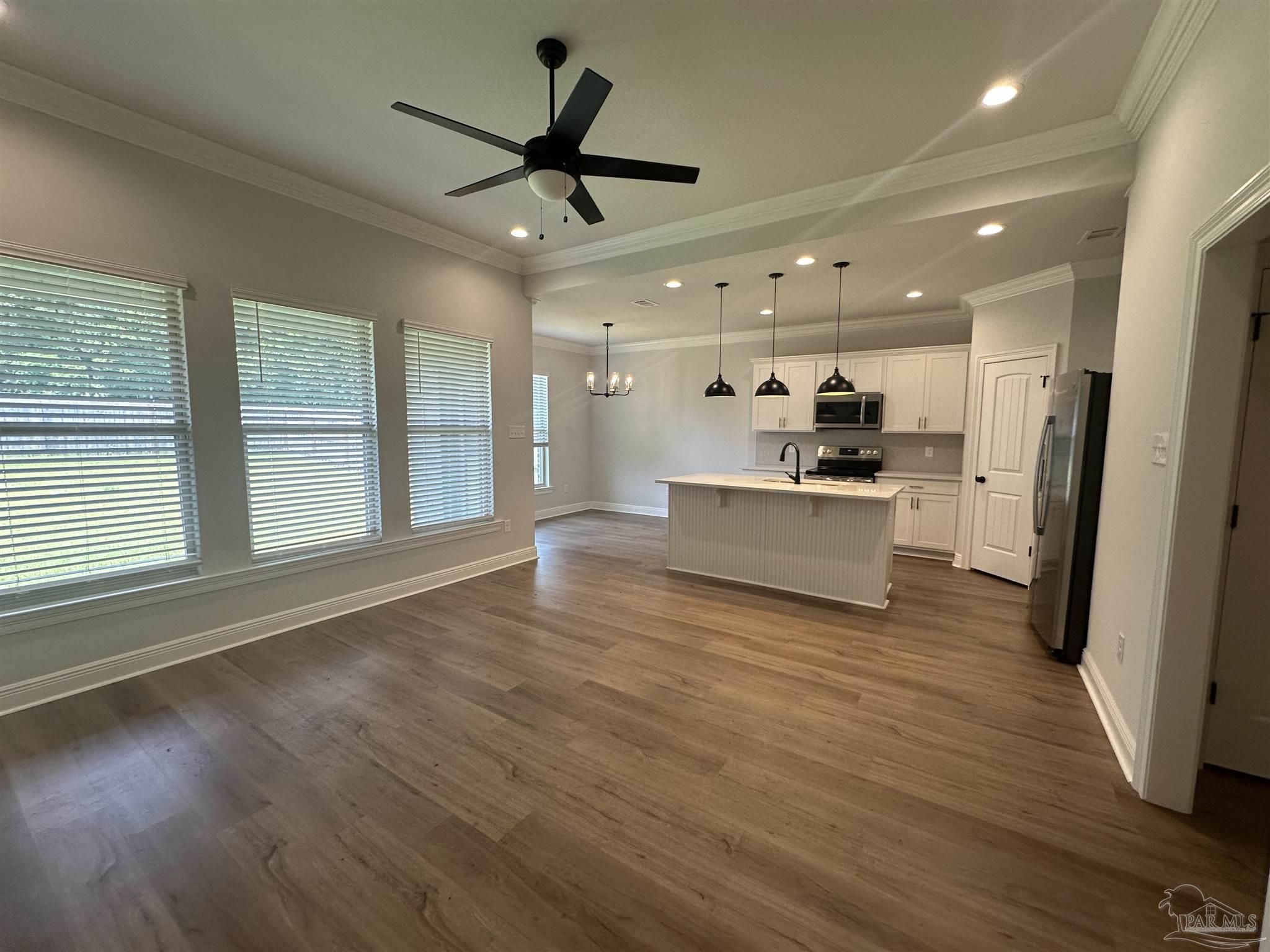 4753 Sago Palm Circle Pace, FL 32571 - Photo 3 of 24 a view of a big room with wooden floor and a kitchen
