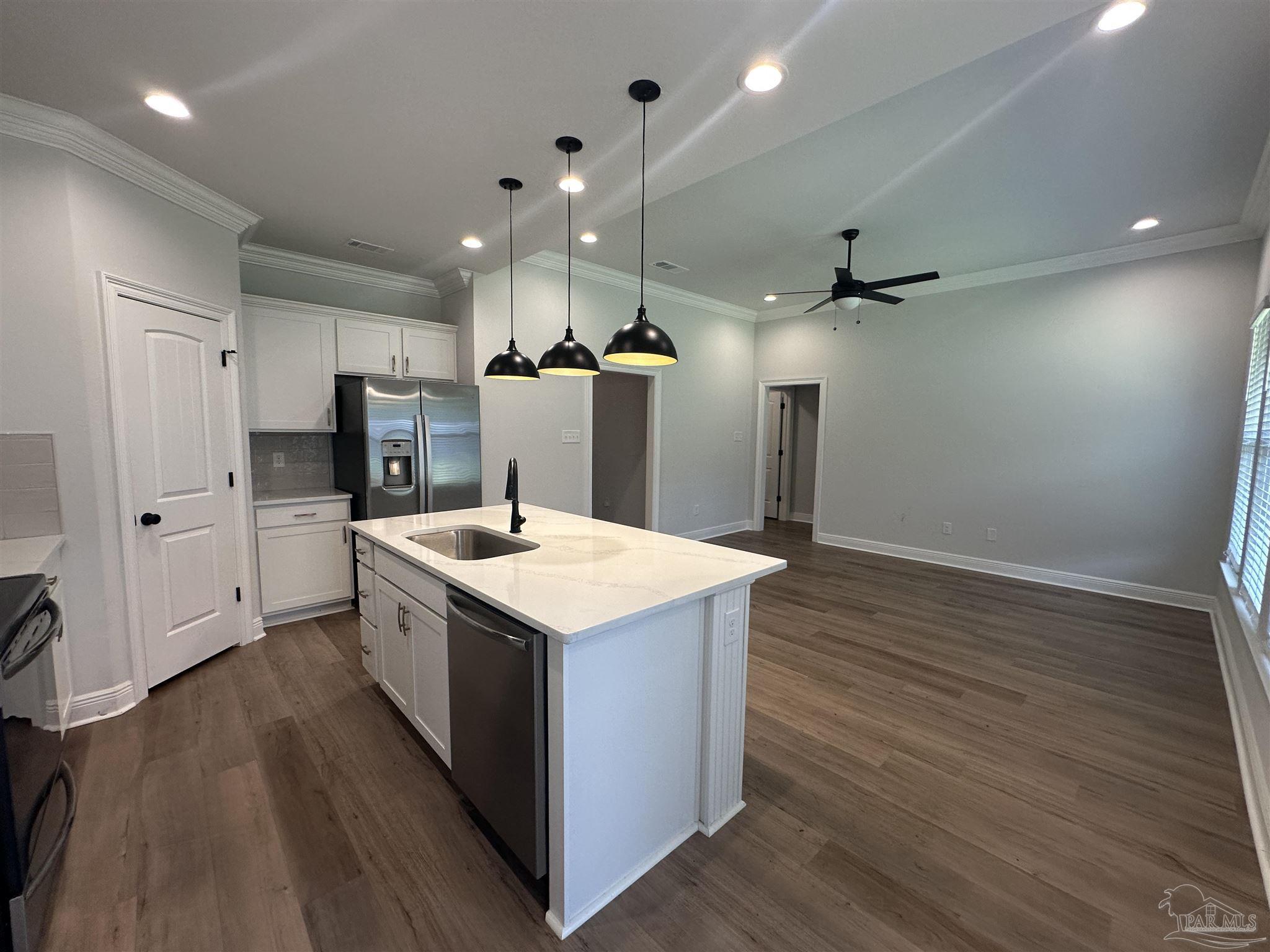 4753 Sago Palm Circle Pace, FL 32571 - Photo 7 of 24 a kitchen with a refrigerator a sink and wooden floor