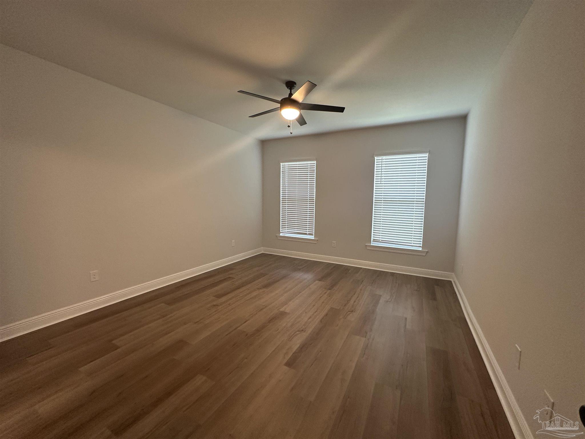 4753 Sago Palm Circle Pace, FL 32571 - Photo 9 of 24 an empty room with wooden floor ceiling fan and window