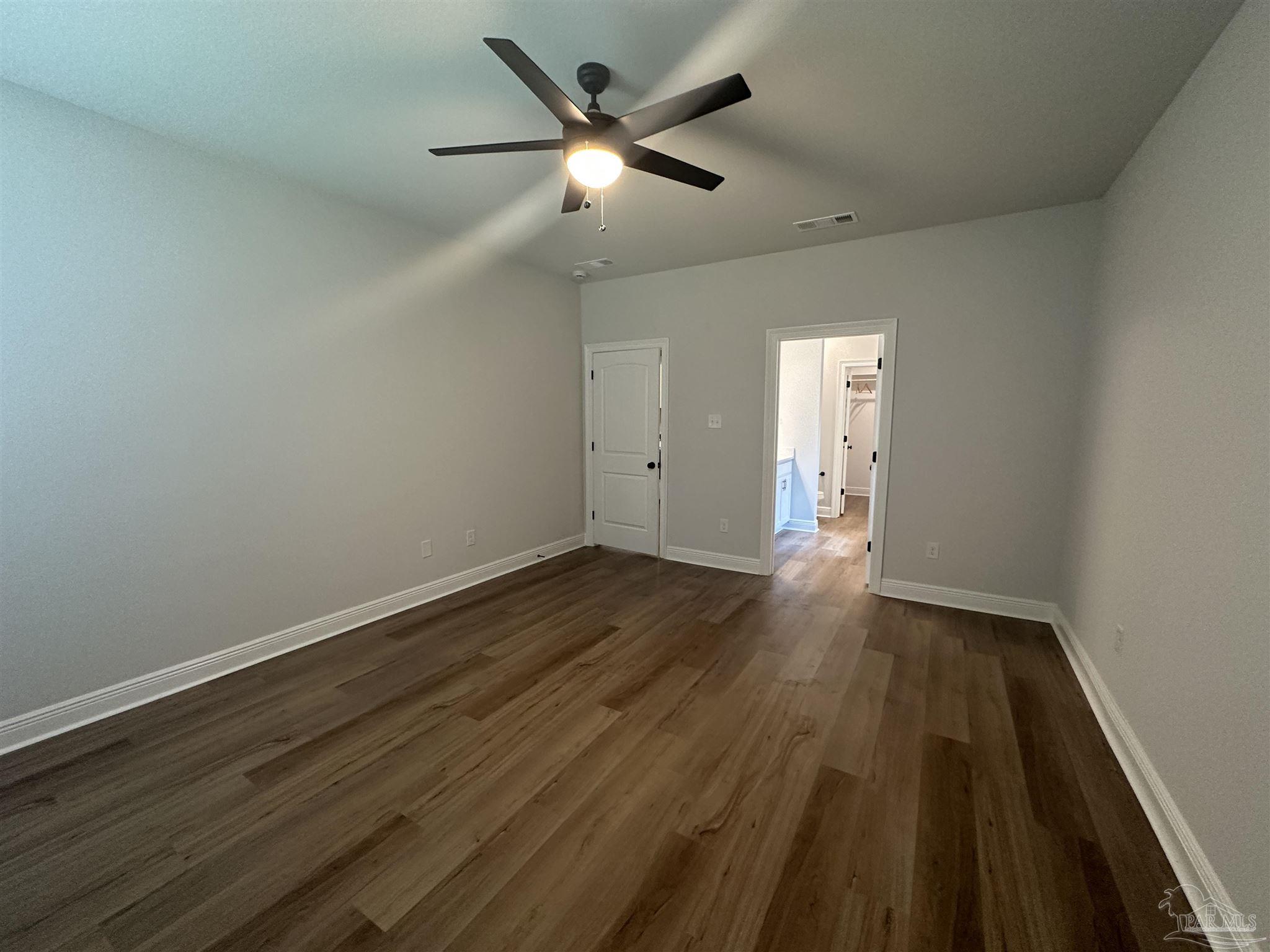 4753 Sago Palm Circle Pace, FL 32571 - Photo 10 of 24 an empty room with wooden floor and a ceiling fan