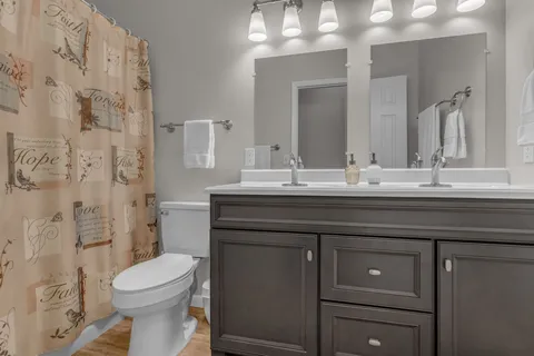 a kitchen with granite countertop white cabinets and wooden floor