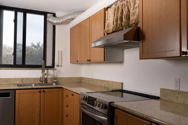 a bathroom with a granite countertop sink a toilet and shower
