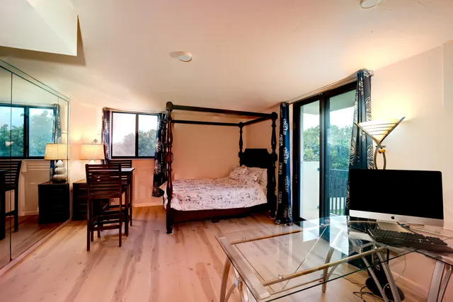 a bedroom with a bed and wooden floor