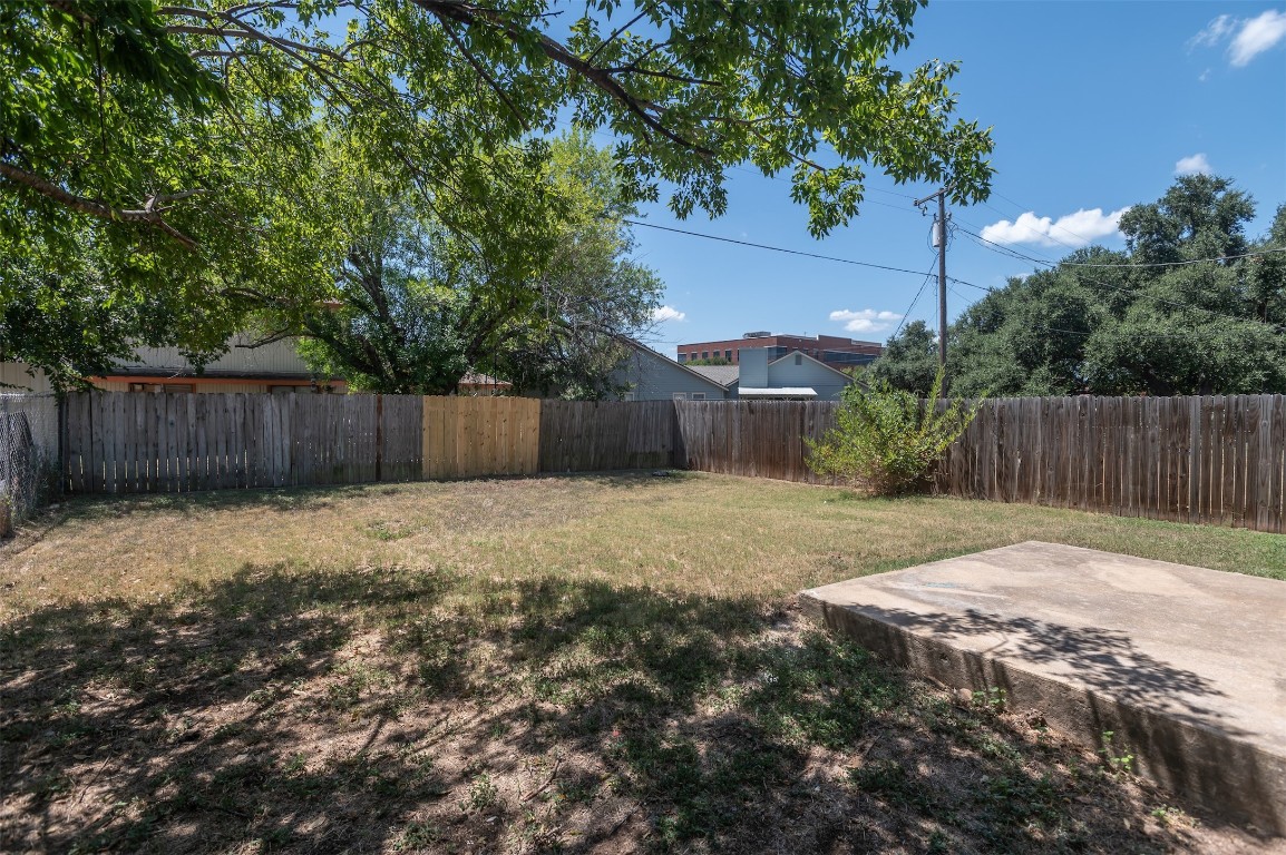 403 West Bowman Road, Unit A Round Rock, TX 78664 - Photo 17 of 17 a view of a backyard with large trees and wooden fence