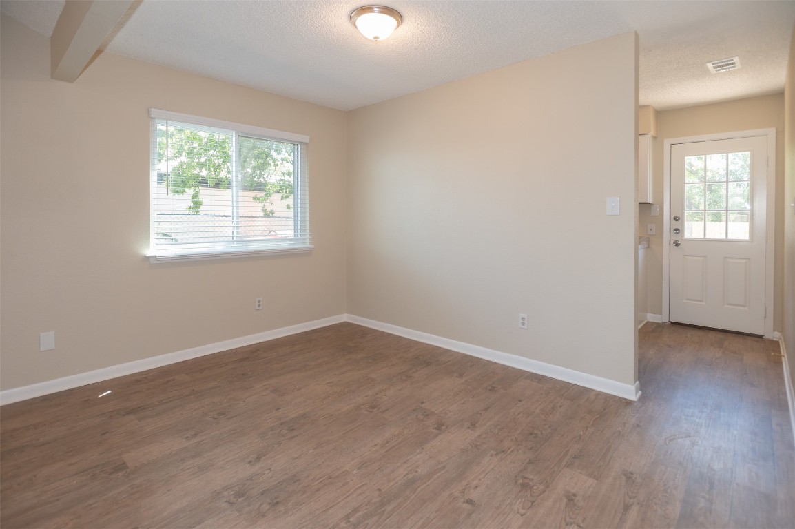 403 West Bowman Road, Unit A Round Rock, TX 78664 - Photo 6 of 17 an empty room with wooden floor and windows