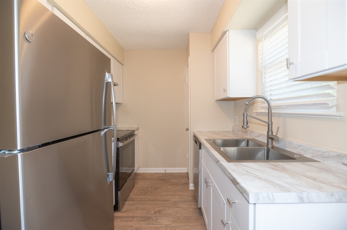 403 West Bowman Road, Unit A Round Rock, TX 78664 - Photo 7 of 17 a kitchen with stainless steel appliances granite countertop a refrigerator and a sink