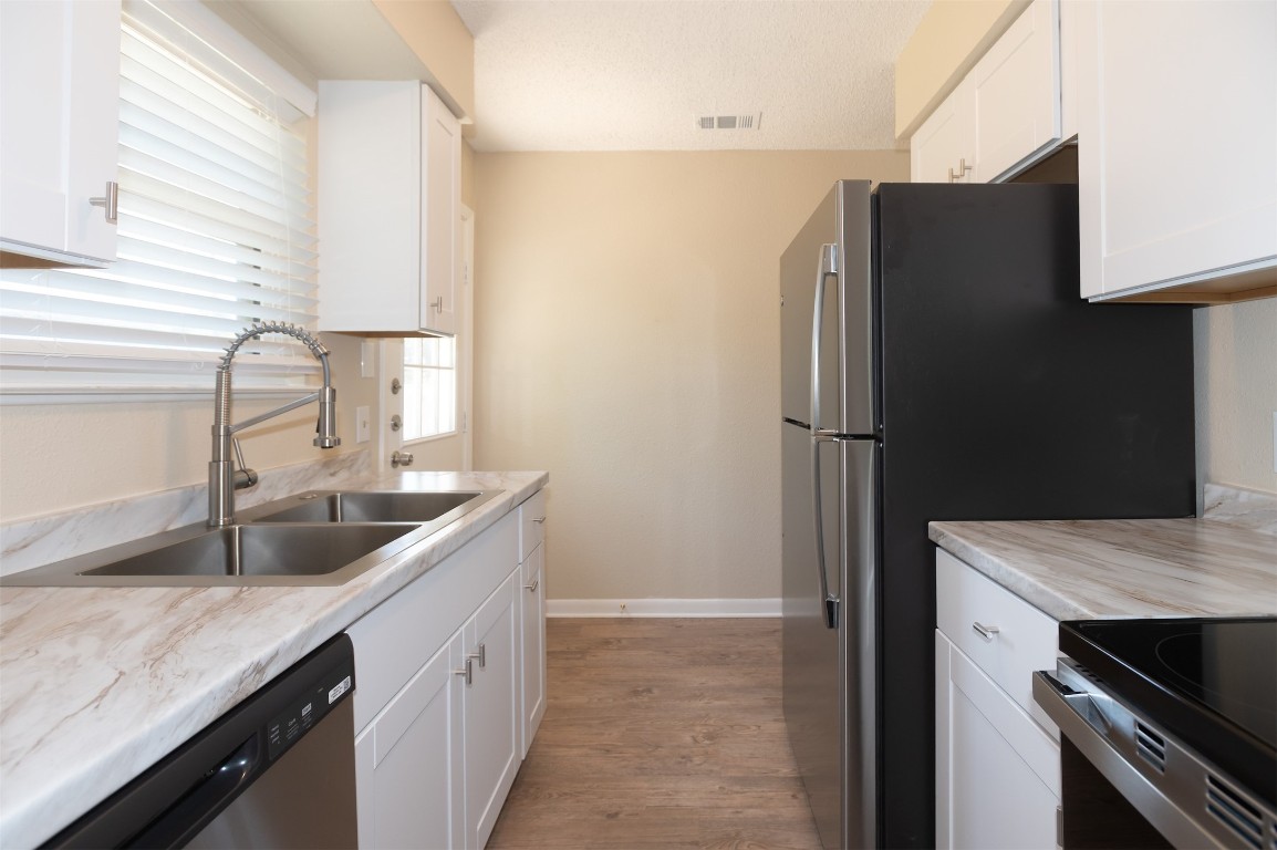 403 West Bowman Road, Unit A Round Rock, TX 78664 - Photo 8 of 17 a kitchen with granite countertop a refrigerator and a sink