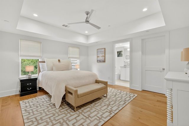 a spacious bedroom with a bed and wooden floor