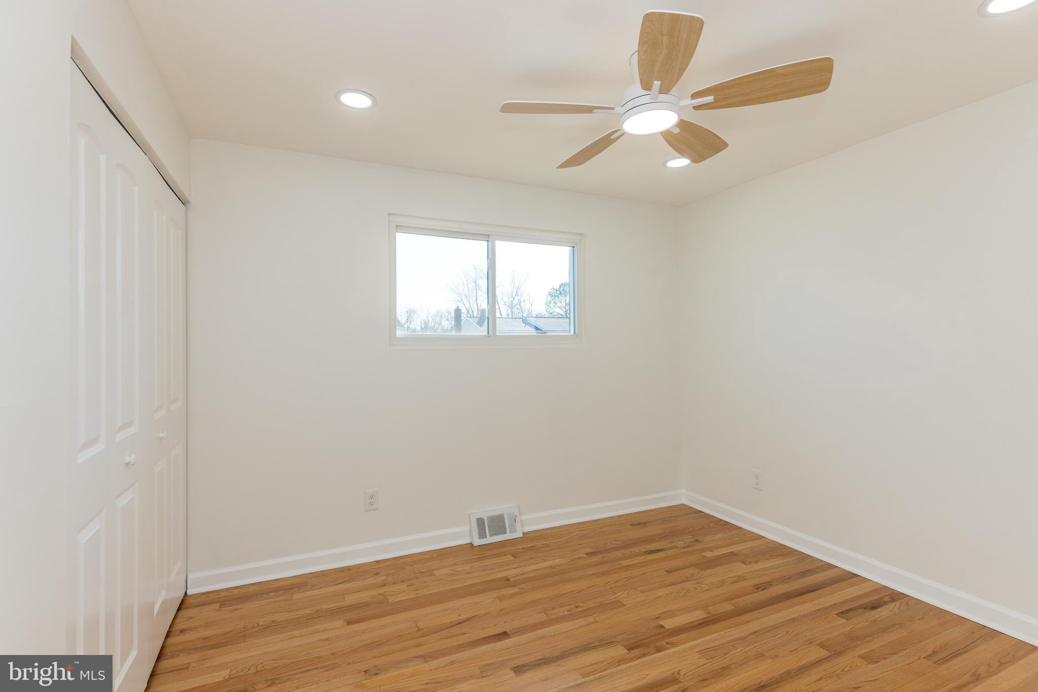 5510 Daybreak Terrace Baltimore, MD 21206 - Photo 19 of 43 an empty room with wooden floor and windows