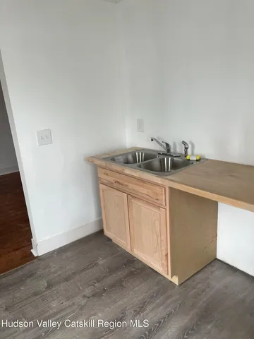 a kitchen with granite countertop a sink and a stove with wooden floor