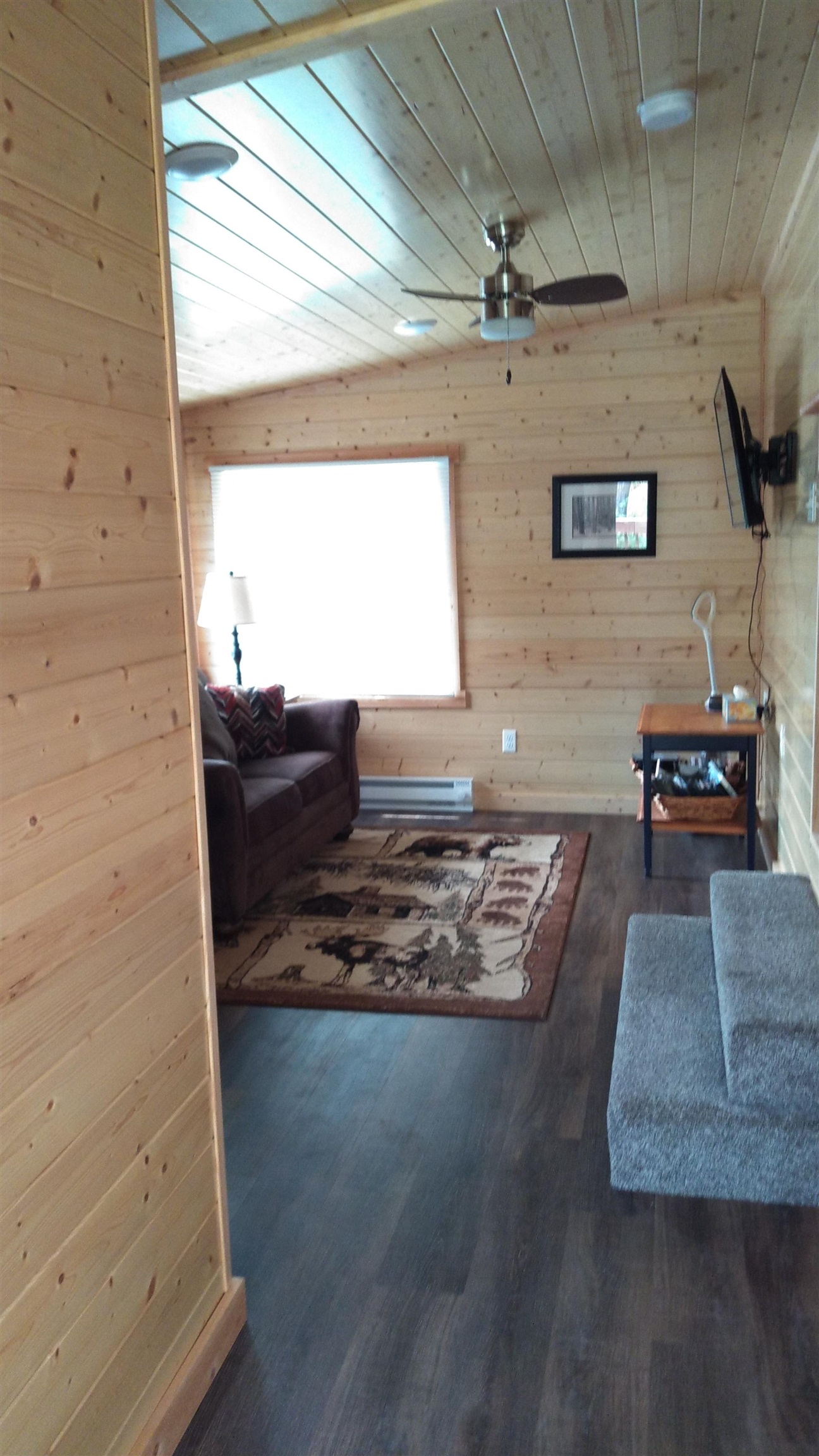 13496 Pine Road, Unit 10 Ely, MN 55731 - Photo 11 of 26 Living area with wood walls, wooden ceiling, dark wood-style floors, a ceiling fan, and baseboard heating