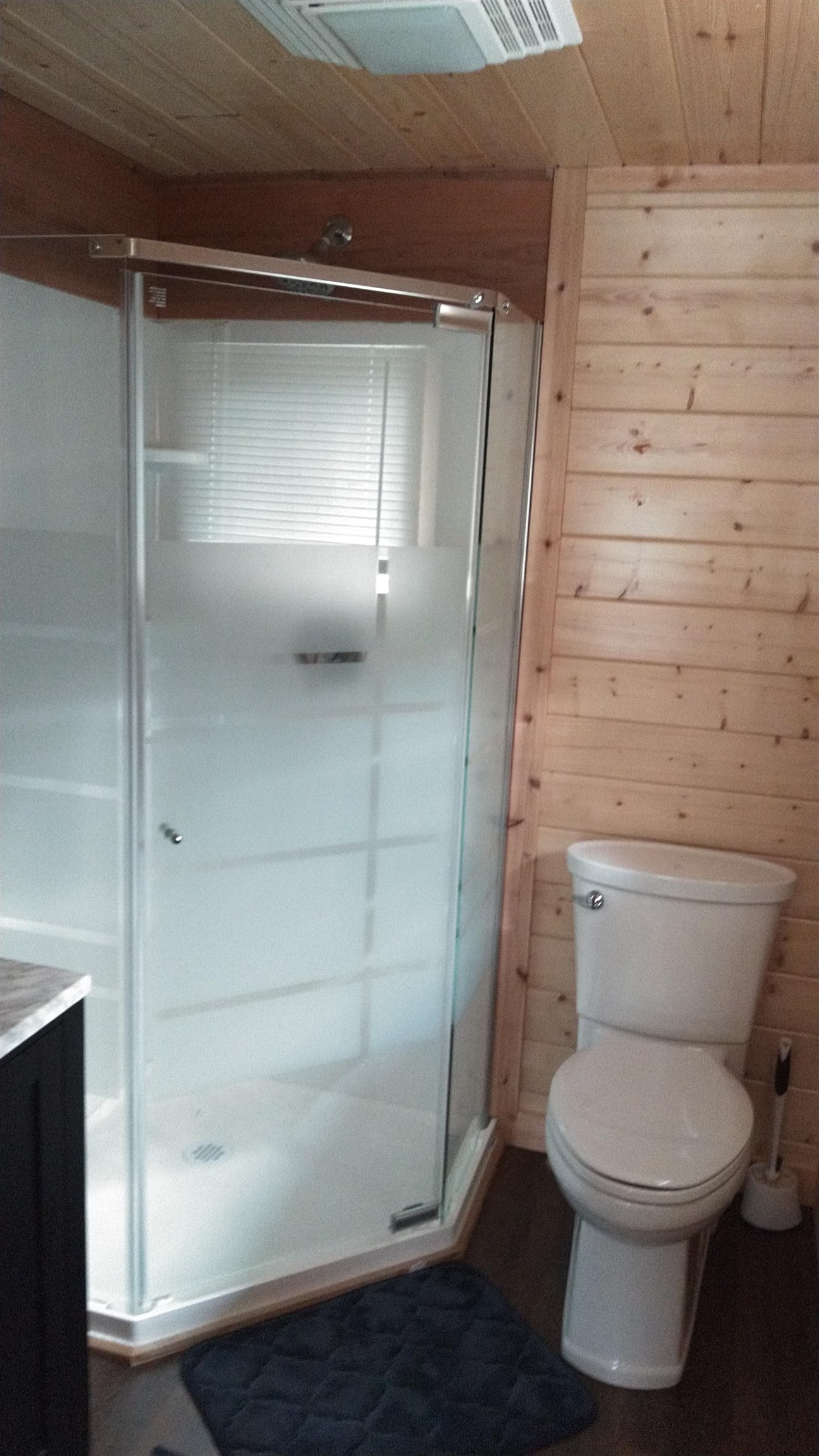 13496 Pine Road, Unit 10 Ely, MN 55731 - Photo 16 of 26 Full bath with a stall shower, wooden walls, vanity, and wood finished floors