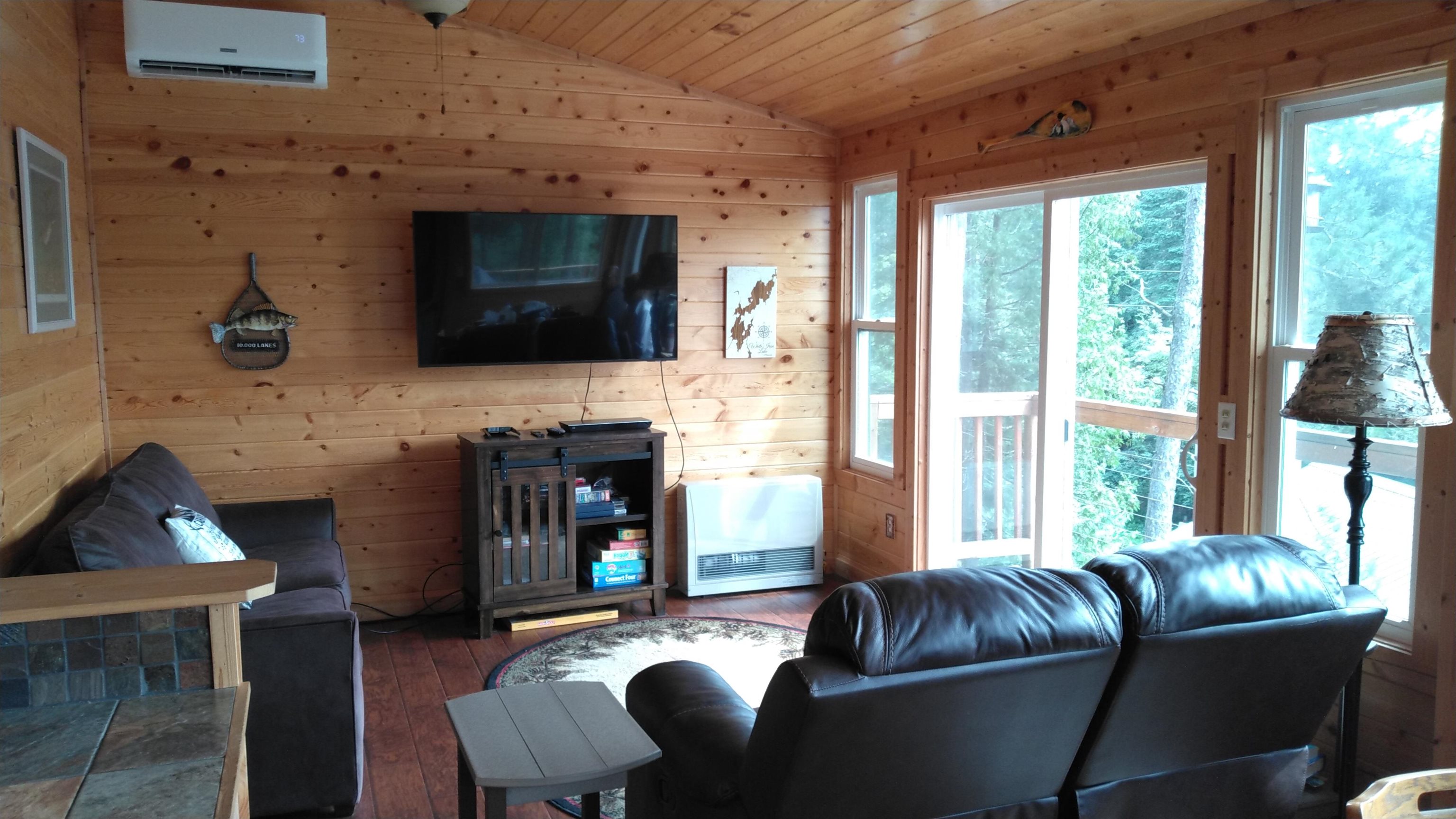 13496 Pine Road, Unit 10 Ely, MN 55731 - Photo 3 of 26 Living area with wooden walls, vaulted ceiling, hardwood / wood-style floors, wood ceiling, and a wall unit AC