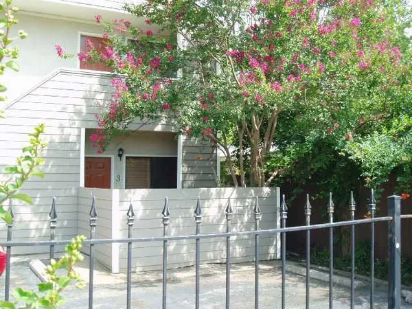 a front view of a house with a tree