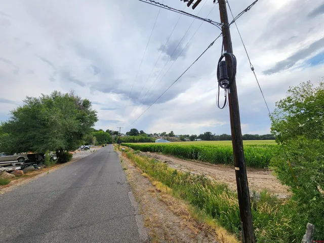 a view of a street with next to a yard