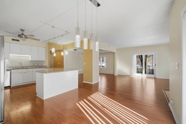 a open kitchen with white cabinets and wooden floor