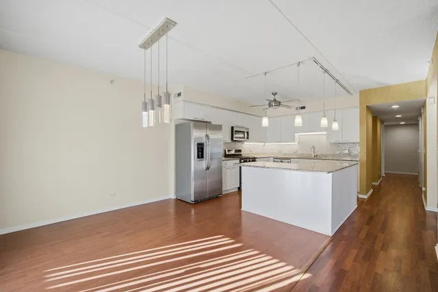 a kitchen with kitchen island white cabinets and stainless steel appliances