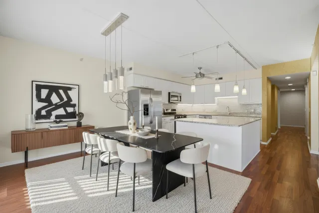 a dining area with a table chairs and a kitchen view