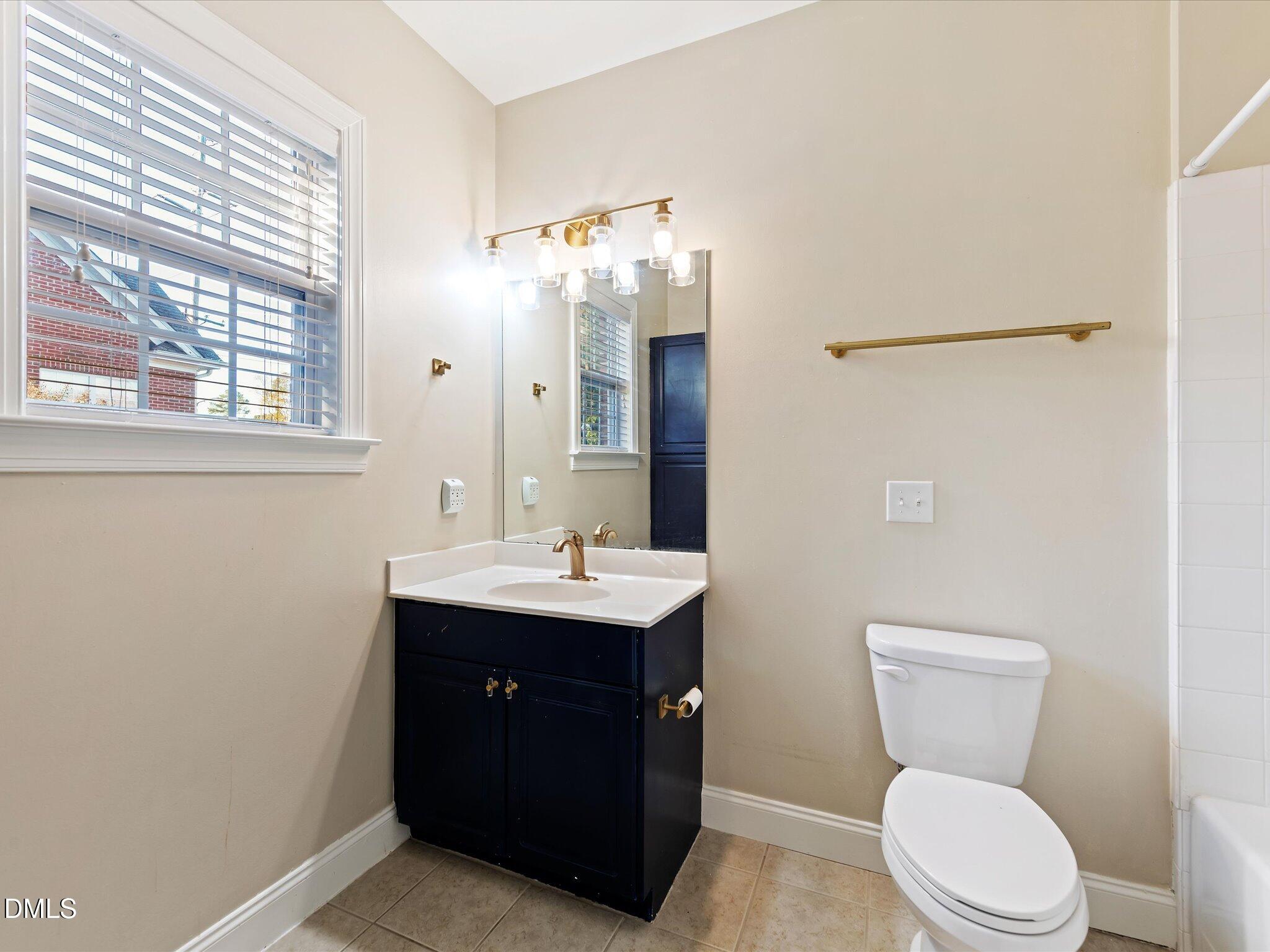 606 Highpark Lane Raleigh, NC 27608 - Photo 23 of 27 a bathroom with a toilet a sink and mirror