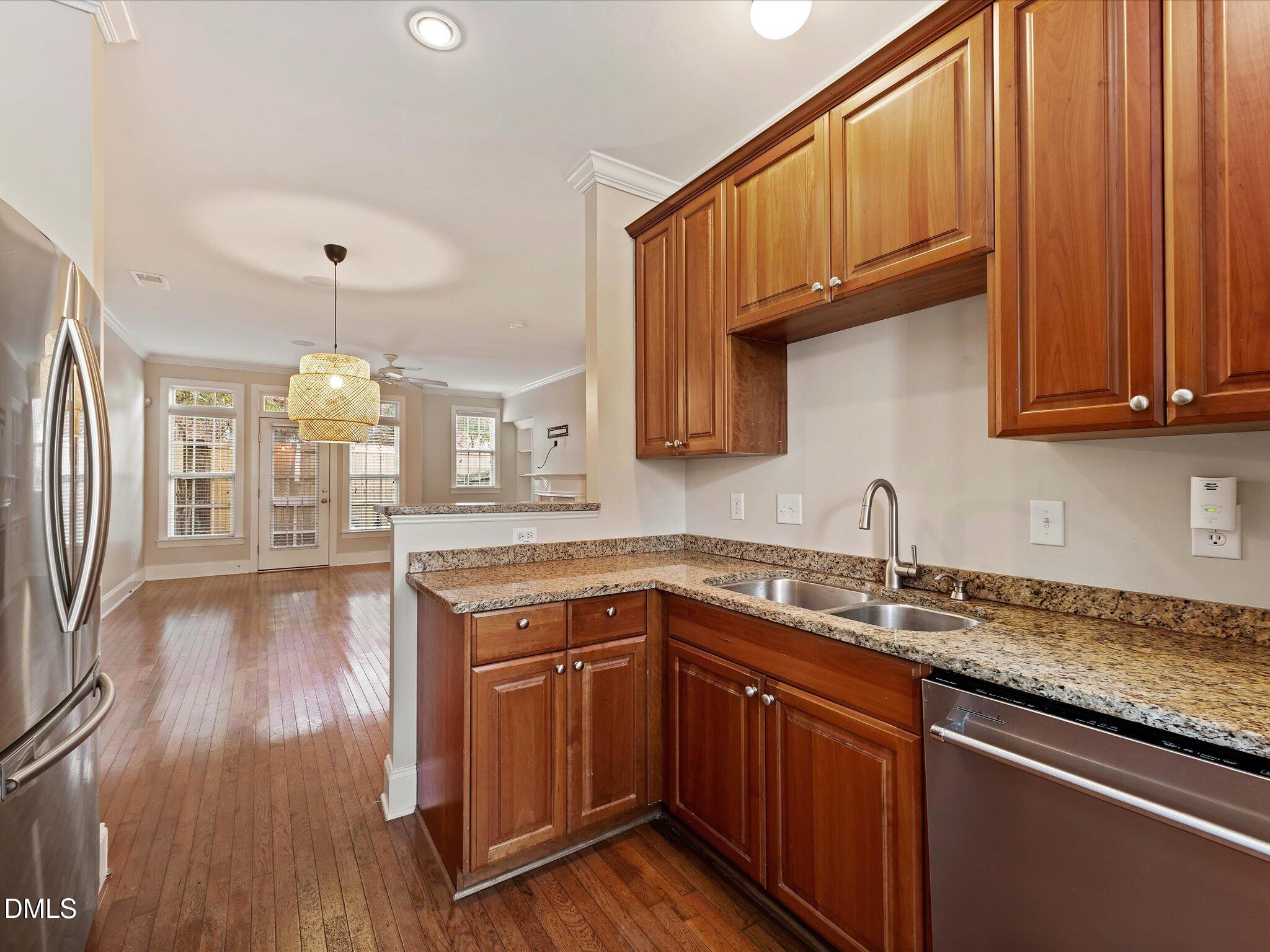 606 Highpark Lane Raleigh, NC 27608 - Photo 4 of 27 a kitchen with granite countertop a sink stainless steel appliances wooden floor and cabinets