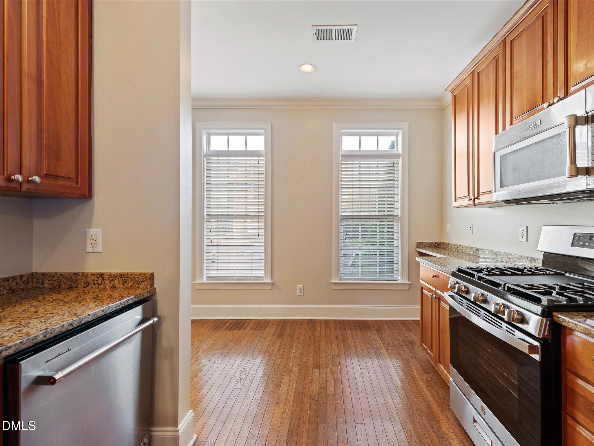 606 Highpark Lane Raleigh, NC 27608 - Photo 5 of 27 a kitchen with stainless steel appliances granite countertop a stove and a wooden cabinets