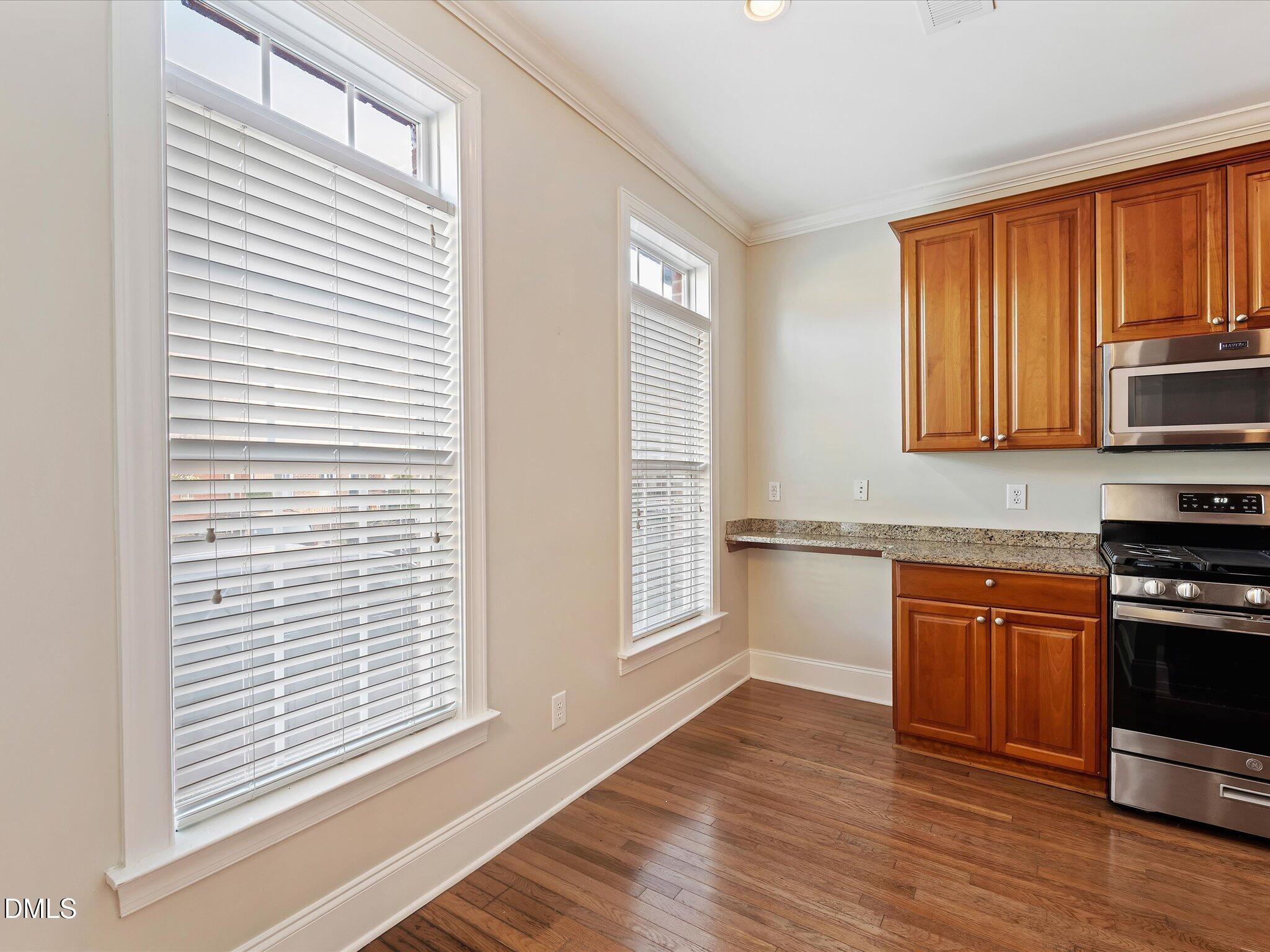 606 Highpark Lane Raleigh, NC 27608 - Photo 7 of 27 a kitchen with stainless steel appliances granite countertop a stove a sink and a microwave