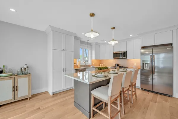 a kitchen with a dining table chairs refrigerator and microwave