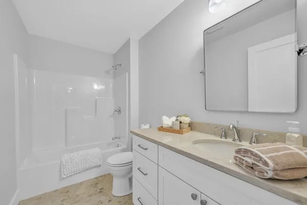 a bathroom with a granite countertop toilet a sink and a bathtub