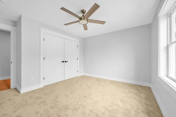 an empty room with windows and fan