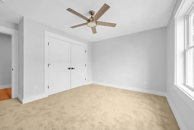an empty room with windows and fan