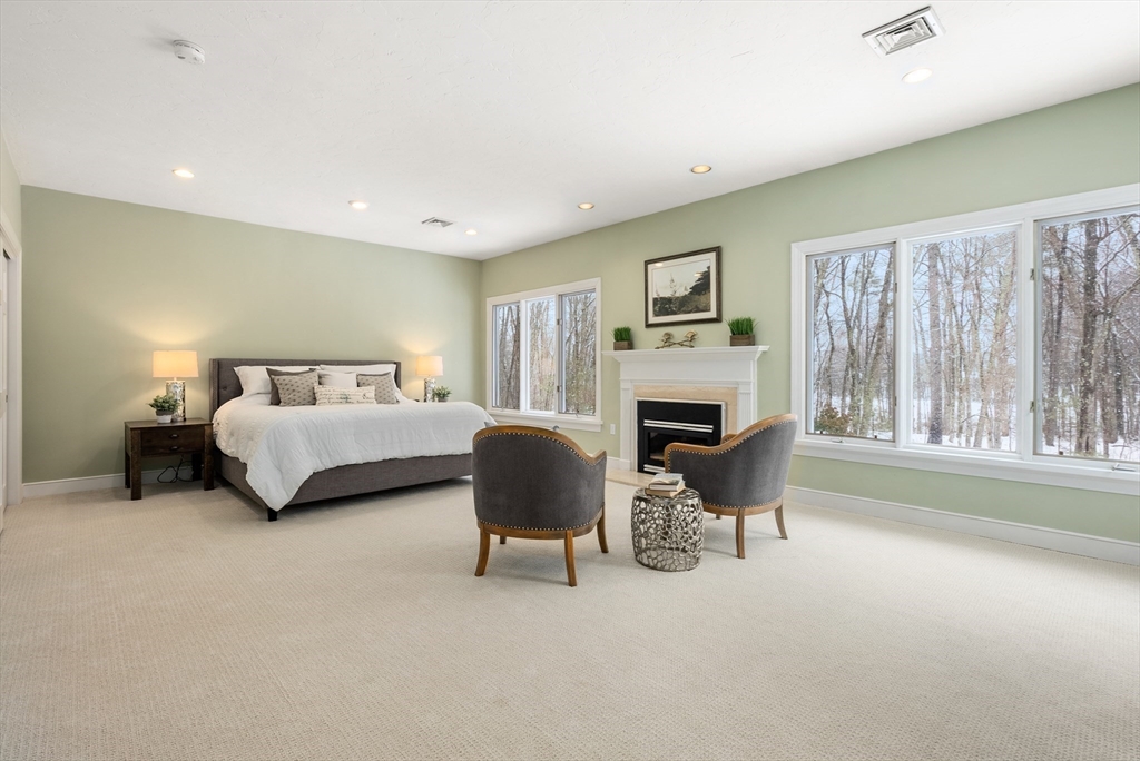 84 Phillips Road Sudbury, MA 01776 - Photo 15 of 34 a spacious bedroom with a bed and a fireplace