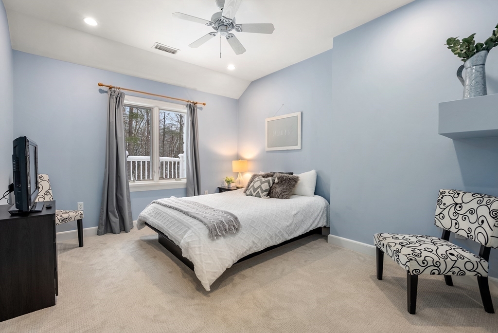 84 Phillips Road Sudbury, MA 01776 - Photo 22 of 34 a bedroom with a bed and a chandelier