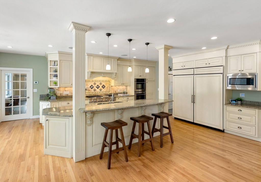 84 Phillips Road Sudbury, MA 01776 - Photo 6 of 34 a kitchen with stainless steel appliances granite countertop a refrigerator a stove and white cabinets with wooden floor