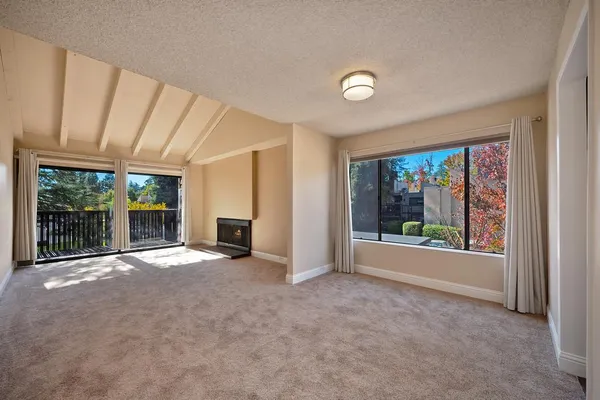 an empty room with floor to ceiling windows and yard