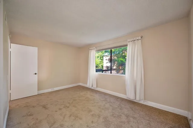 a backyard of a house with table and chairs wooden floor and fence