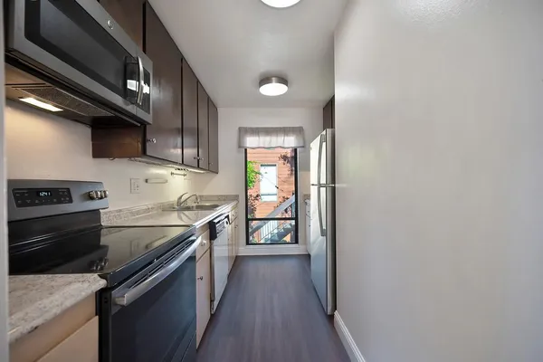 a kitchen with stainless steel appliances granite countertop a refrigerator and a stove