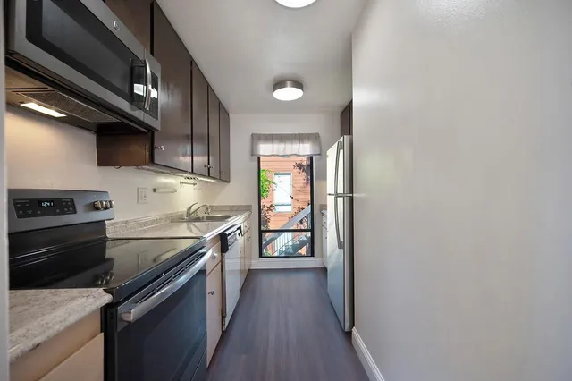 a kitchen with stainless steel appliances granite countertop a refrigerator and a stove