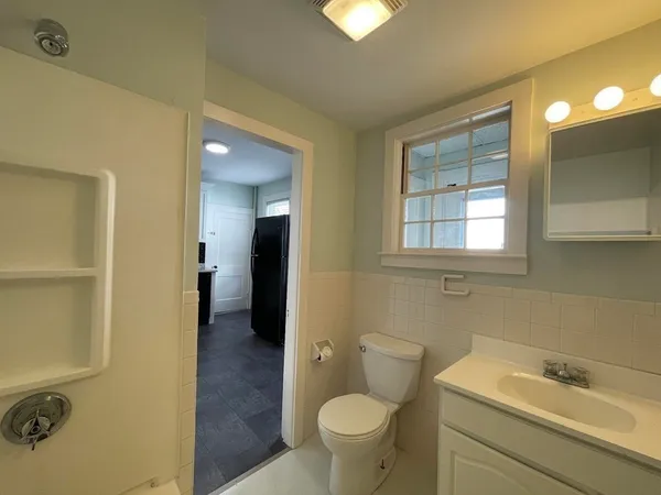 a bathroom with a granite countertop sink and a washing machine