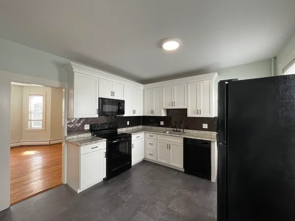 a kitchen with stainless steel appliances granite countertop a stove top oven a sink dishwasher and a refrigerator